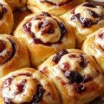 Freshly baked Wild Blueberry Ricotta Sweet Buns on a rustic wooden table, garnished with powdered sugar and blueberries.